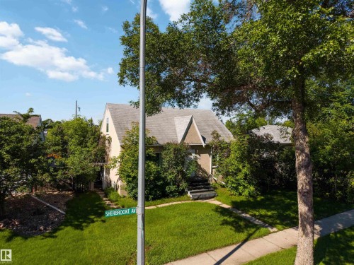 Gabled roofline property featuring a stucco exterior and mature trees - 12943 Sherbrooke Avenue, Edmonton, AB 