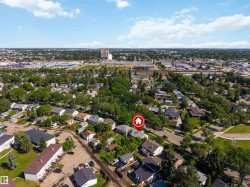 Aerial perspective showcasing an established neighborhood with a mix of residential structures and abundant mature trees - 