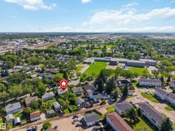 Aerial perspective of a residential neighborhood featuring established homes with mature trees and green spaces - 