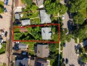 Aerial perspective showcasing the property's perimeter, featuring a single-family residence with a gray shingled roof, a detached auxiliary structure, and established landscaping with mature trees - 12943 Sherbrooke Avenue, Edmonton, AB 