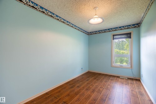 Room featuring wood-finish flooring, light blue walls, and a single window - 59228 Rg Rd 11, Rural Westlock County, AB 