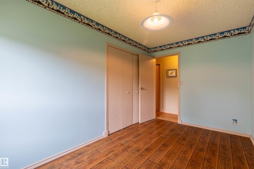 Room featuring wide-plank wood-finish flooring, light blue walls, and a popcorn ceiling - 59228 Rg Rd 11, Rural Westlock County, AB 