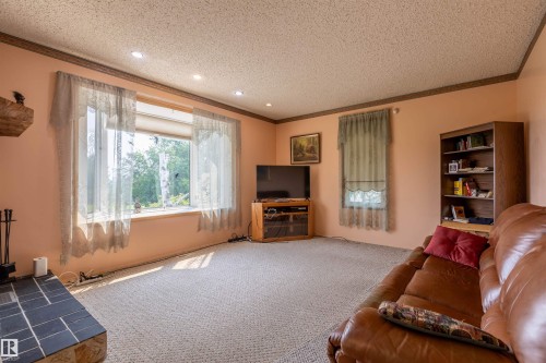 Carpeted living space featuring a large picture window, recessed lighting, and a built-in bookshelf - 59228 Rg Rd 11, Rural Westlock County, AB 