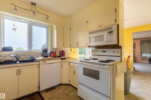 Kitchen with white cabinetry, a built-in microwave, and a white electric range - 59228 Rg Rd 11, Rural Westlock County, AB 