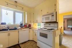 Kitchen with white cabinetry, a built-in microwave, and a white electric range - 