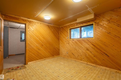 Room featuring diagonal wood paneling and two ceiling-mounted flush light fixtures - 59228 Rg Rd 11, Rural Westlock County, AB 