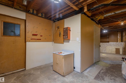 Exposed wood beam ceiling in a utilitarian room featuring a light wood-finish door with a glass panel - 59228 Rg Rd 11, Rural Westlock County, AB 