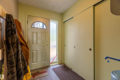 Entryway featuring a paneled door with an arched window, frosted sidelight, and wood-finish flooring - 59228 Rg Rd 11, Rural Westlock County, AB 