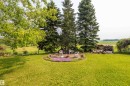 Expansive green lawn featuring a circular stone patio with a central fire pit - 59228 Rg Rd 11, Rural Westlock County, AB 
