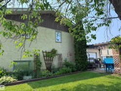 Exterior stucco siding with a wood-paneled upper facade - 