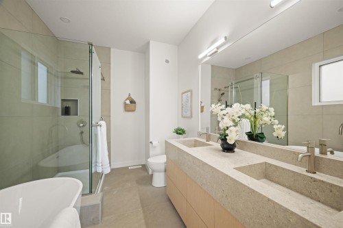 Bathroom featuring a double vanity with integrated rectangular sinks, a freestanding tub, and a glass-enclosed shower with a built-in niche - 14037 104 Avenue, Edmonton, AB - Indoor Photo Showing Bathroom