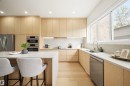 Modern kitchen featuring light wood-finish cabinetry, light stone countertops, stainless steel appliances, and a built-in oven stack - 14037 104 Avenue, Edmonton, AB  - Indoor Photo Showing Kitchen With Upgraded Kitchen 