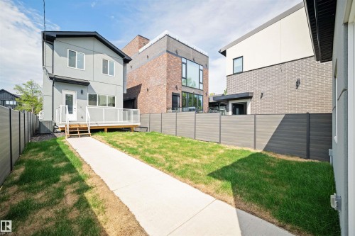 Exterior featuring a light gray facade, a white deck with railings, and a walk-out door - 14037 104 Avenue, Edmonton, AB - Outdoor With Exterior