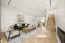Open-concept living area with light wood-finish flooring, recessed lighting, a built-in fireplace, and a light wood staircase featuring glass panel railings - 14037 104 Avenue, Edmonton, AB  - Indoor 