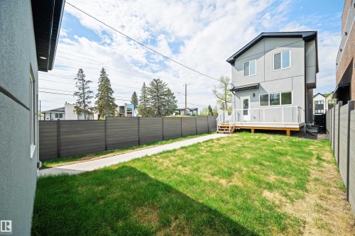Rear exterior of the property featuring a contemporary design with a light gray stucco finish, a dark roof, and multiple windows - 14037 104 Avenue, Edmonton, AB - Outdoor