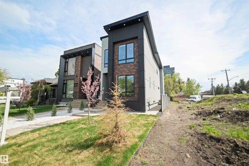 Contemporary exterior featuring dark brick accents, light grey siding, and large black-framed windows - 14037 104 Avenue, Edmonton, AB - Outdoor