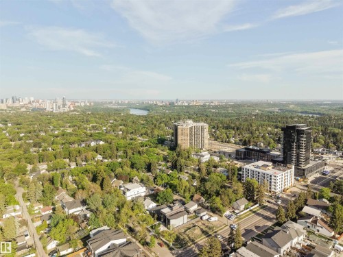 Expansive urban landscape featuring a distant river, a city skyline, dense green tree coverage, commercial structures, and residential properties - 14037 104 Avenue, Edmonton, AB - Outdoor With View
