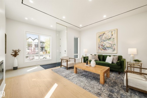 Open concept living space featuring light wood-finish flooring, recessed lighting, and a large front-facing window - 14037 104 Avenue, Edmonton, AB - Indoor Photo Showing Living Room