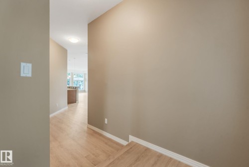 Hallway with light wood-finish flooring and neutral wall tones - 126 10531 117 Street, Edmonton, AB 