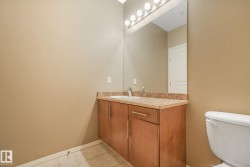 Bathroom vanity with a light wood-finish cabinet, integrated sink, and granite-style countertop - 