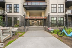 Building facade featuring a prominent entrance with "GATES ON 117th" signage, dark brick accents, and multiple windows - 