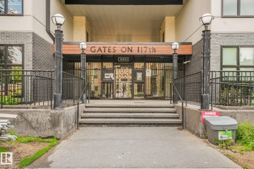 Main entrance featuring concrete steps, wrought iron fencing, decorative address signage, and exterior lighting fixtures - 126 10531 117 Street, Edmonton, AB 
