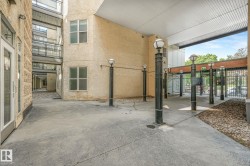 Covered concrete walkway featuring multiple decorative lampposts and secure access gates - 