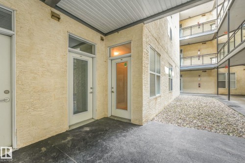 Exterior stucco finish with multiple entry doors featuring glass panel inserts - 126 10531 117 Street, Edmonton, AB 