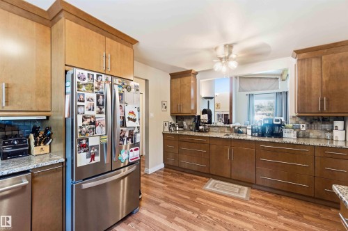 Well-appointed kitchen featuring wood-finish flooring, light wood cabinetry, and granite-look countertops - 13121 122 Street, Edmonton, AB 