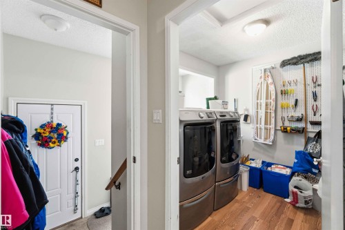 Dedicated laundry area featuring wood-finish flooring and a functional pegboard wall - 13121 122 Street, Edmonton, AB 