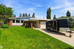Single-story residence featuring a brick and white facade, an attached single-car garage, large front windows, a peaked roofline, and a concrete driveway - 