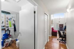 Hallway with wood-finish flooring and light gray walls - 