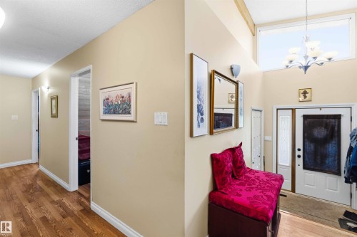 Entryway featuring a double door with decorative glass inserts, a high transom window, and a vaulted ceiling with exposed wood beams - 13121 122 Street, Edmonton, AB 