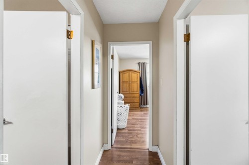 Interior hallway with wood-finish flooring and light beige wall paint - 13121 122 Street, Edmonton, AB 