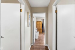 Interior hallway with wood-finish flooring and light beige wall paint - 