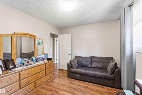 Room featuring wood-finish flooring, a neutral wall color, and an overhead light fixture - 13121 122 Street, Edmonton, AB 