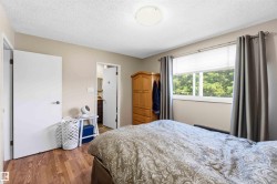 Interior space featuring wood-finish flooring, a window with horizontal blinds, and a flush-mount ceiling light - 