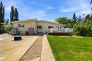 Rear exterior with stucco siding and a spacious wooden deck - 13121 122 Street, Edmonton, AB 