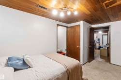 Wood-paneled ceiling with track lighting, neutral wall finishes, and wood-finish doors - 