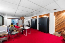 Room featuring red carpeting, wood-paneled accents, and a drop ceiling - 