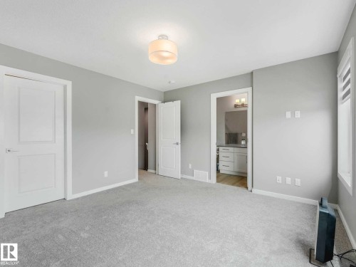 Spacious room with light gray carpeting and neutral wall tones - 516 35 Street, Edmonton, AB 