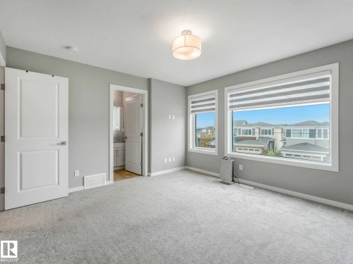 Spacious room featuring light gray carpet flooring and neutral wall tones - 516 35 Street, Edmonton, AB 