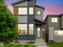 Modern two-story residence featuring a striking multi-textured facade with horizontal siding, dark accent panels, and natural wood-tone cladding - 516 35 Street, Edmonton, AB 