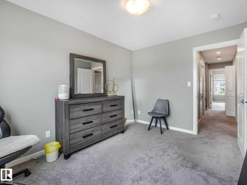 Plush grey carpeting extends throughout this room, complemented by light grey wall paint - 516 35 Street, Edmonton, AB 