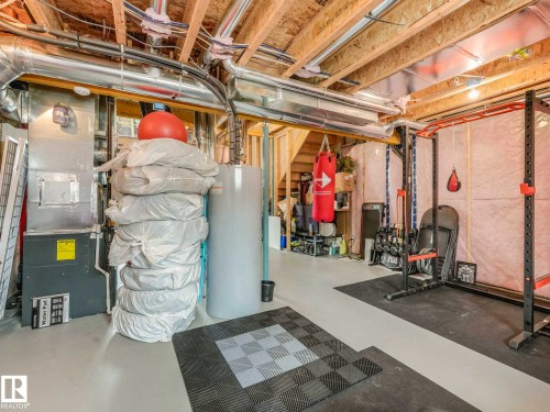 Unfinished basement featuring exposed wood joists, ductwork, and a utility area - 516 35 Street, Edmonton, AB 