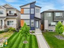 Modern two-story home featuring a contemporary facade with contrasting grey and blue siding, complemented by wood-look panel accents - 516 35 Street, Edmonton, AB 