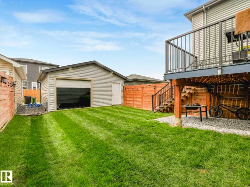 Expansive backyard featuring a detached garage, manicured lawn, and a multi-level deck with stairs - 516 35 Street, Edmonton, AB 