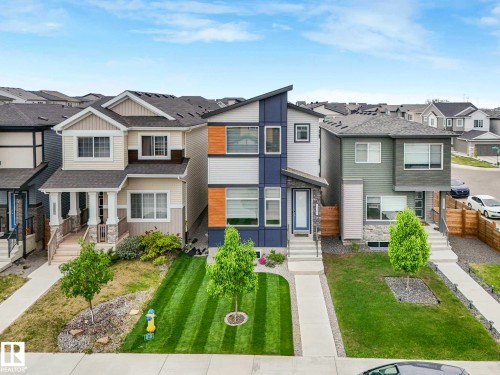 Contemporary exterior featuring multiple siding textures, a prominent entryway, and a clean concrete walkway - 516 35 Street, Edmonton, AB 