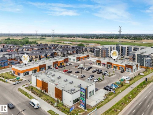 Aerial perspective of a commercial complex featuring multiple retail storefronts and ample surface parking - 516 35 Street, Edmonton, AB 