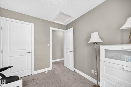 Neutral-toned room featuring a white paneled door, light gray walls, and gray carpeted flooring - 10-415 Clareview Rd Nw Nw, Edmonton, AB 